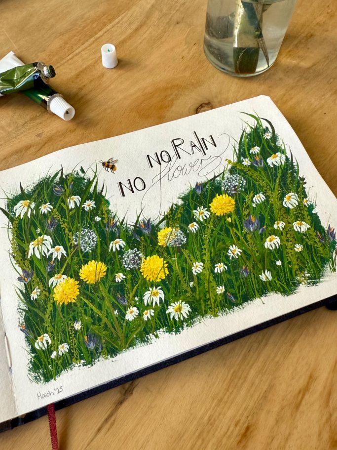 Ein offenes Skizzenbuch mit bunten Blumen und grünem Gras.