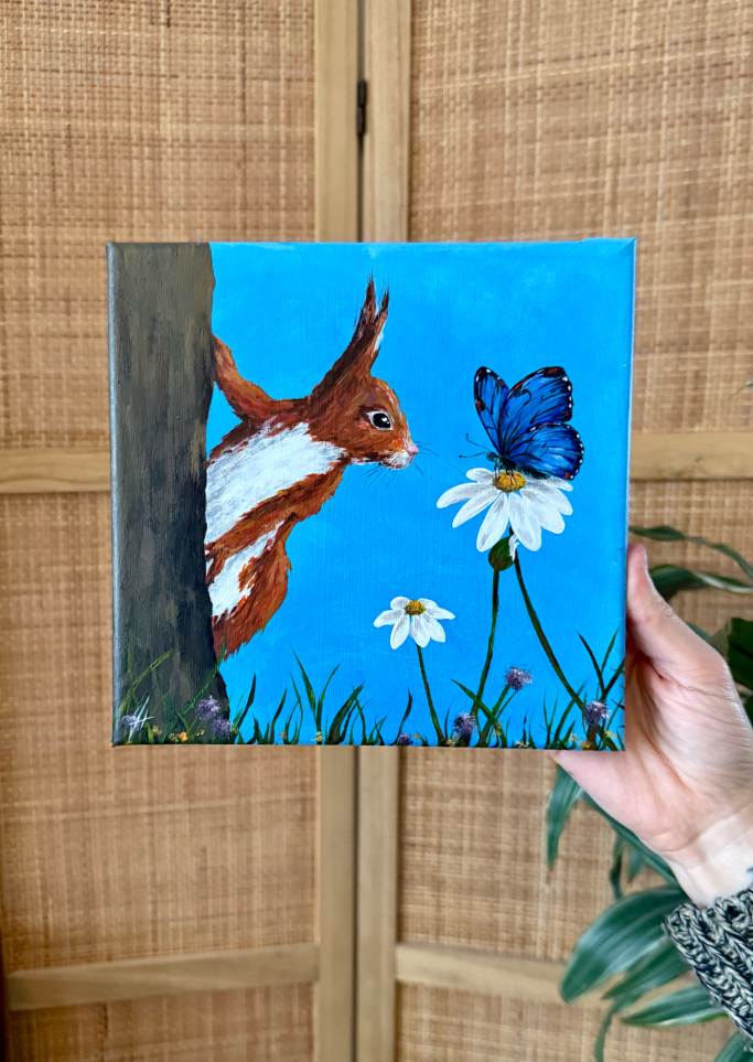 Ein Eichhörnchen schaut neugierig auf einen blauen Schmetterling und eine Blume.