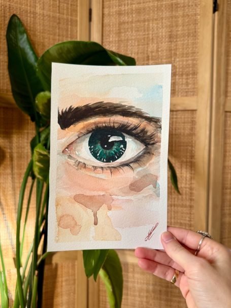 Aquarellzeichnung eines menschlichen Auges mit klaren blauen Farben und sanften Konturen.