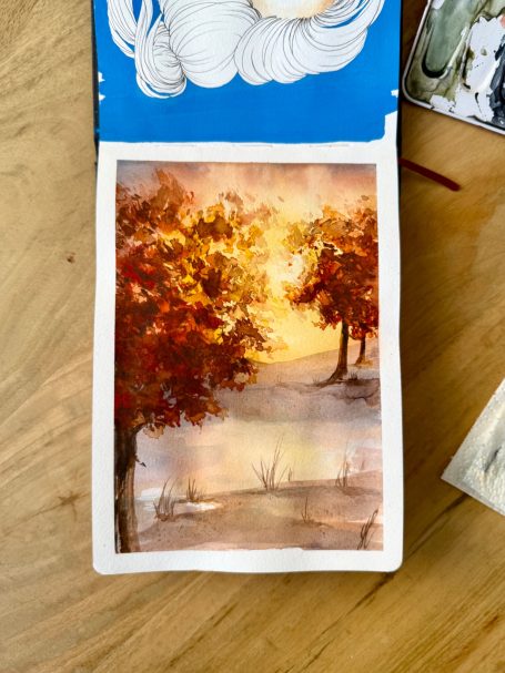 Herbstliche Landschaft mit bunten Bäumen und einem ruhigen See im Sonnenlicht.