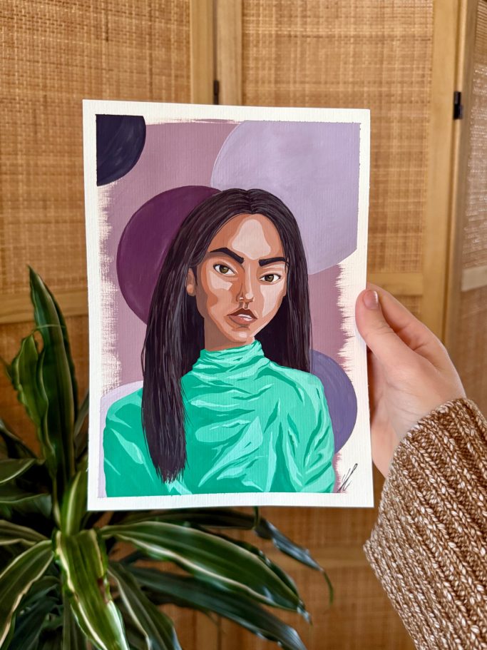 Porträt einer Person mit langen Haaren in grüner Bluse vor einem bunten Hintergrund.