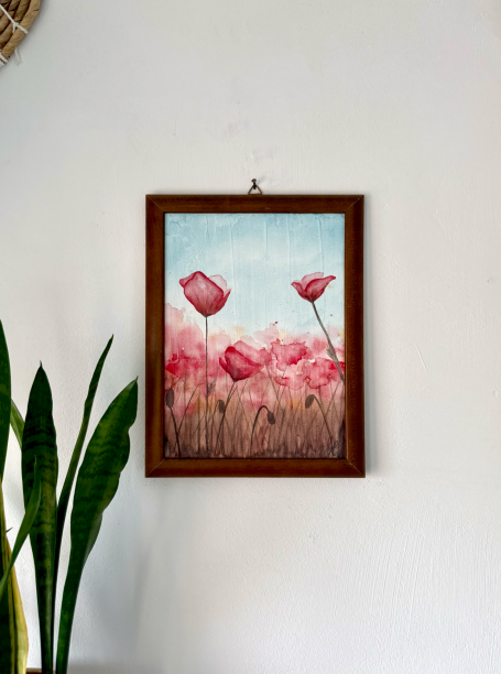 Aquarellgemälde von rosa Blumen auf hellem Hintergrund in schlichtem Rahmen.