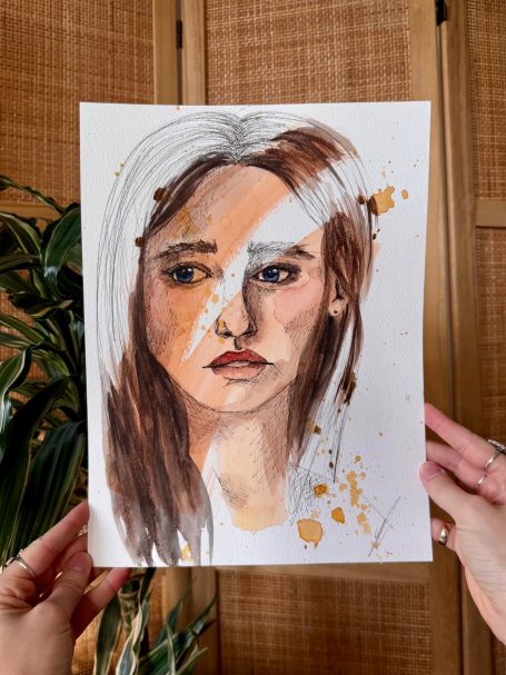 Porträt einer Frau mit langen, braunen Haaren und nachdenklichem Ausdruck.