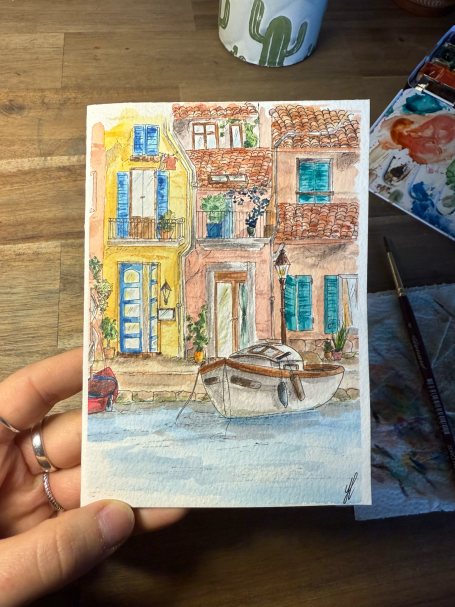 Bunte Aquarellzeichnung eines Hauses am Wasser mit einem Boot und Pflanzen.